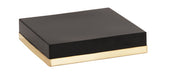 A closed, rectangular black box with smooth surfaces and a flat lid. The bottom edge is wrapped in a shiny, metallic gold band, giving it a modern, minimalist appearance—like a Monaco cube riser—set against a plain white background.