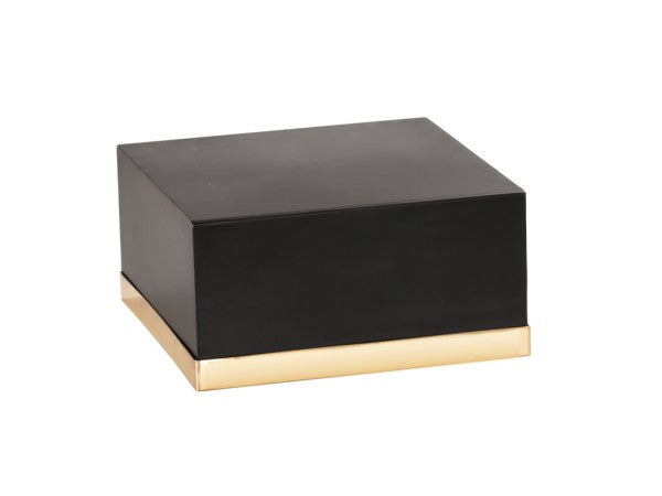 A square, matte black Monaco box with a shiny, gold-colored base sits on a white background. The cube has sharp edges and a simple, modern design with no visible markings or decorations.