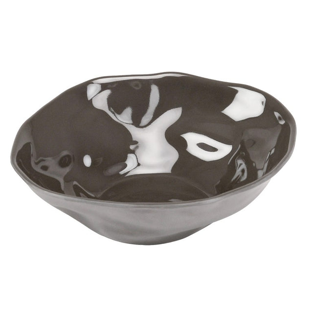 A black ceramic Marin Bowl with an irregular, wavy rim and a reflective, glossy surface. The interior features white patches that create a marbled effect, giving this melamine bowl an abstract, organic appearance.