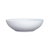 A white serving bowl with a subtle textured pattern on its exterior. This shallow ceramic bowl features a slightly flared rim and small, flat base, and is placed on a plain white background.