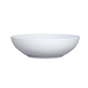 A white serving bowl with a subtle textured pattern on its exterior. This shallow ceramic bowl features a slightly flared rim and small, flat base, and is placed on a plain white background.