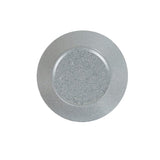 A round, clear glass plate with a wide rim, featuring small silver speckles scattered evenly across the surface. The background is plain white, and the plate is photographed from above, highlighting its smooth, glossy texture and subtle matte finish.