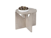 A small, round, gray-washed pine wood table with intersecting panel legs. On top, there is a white plate filled with chocolate-glazed donuts topped with yellow sprinkles. The background is plain white.