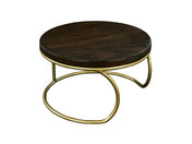 A round Heritage Riser coffee table with a dark stained oak top and a unique matte gold wire base featuring curved, overlapping legs, set against a white background. The modern design contrasts rich wood with the elegant metallic frame.