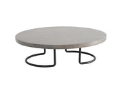 A round, light gray coffee table with a thick, smooth tabletop and a modern wire frame base made of black curved legs that form semi-circular shapes underneath. The table has a minimalist and contemporary design.