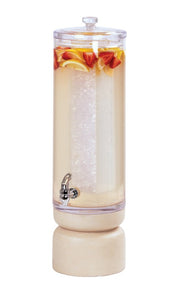 A tall, clear 3-gallon Beverage Dispenser with a domed lid is filled with a pale drink, ice, and pieces of strawberries and lemon slices. It features a metal spigot near the base and sits on a round, light-colored stand.