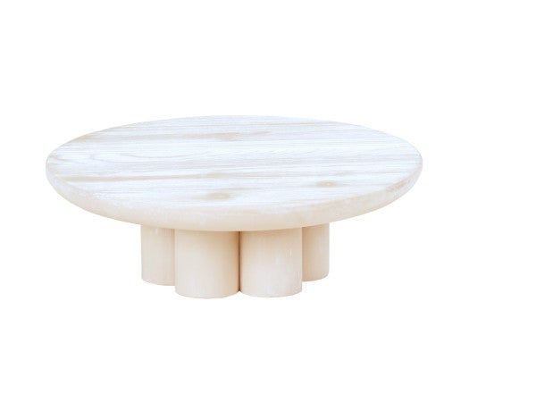 A round, white-washed pine wood coffee table with a smooth top surface and six short, cylindrical legs arranged in a circular pattern underneath. This minimalist riser features a modern design and is set against a white background.