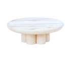 A round, white-washed pine wood coffee table with a smooth top surface and six short, cylindrical legs arranged in a circular pattern underneath. This minimalist riser features a modern design and is set against a white background.