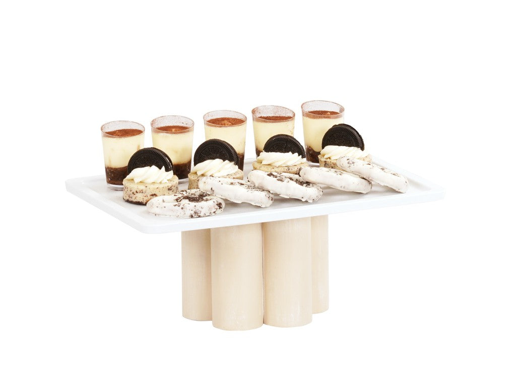 A white-washed pine wood rectangular platter on pedestal riser bases holds six small dessert cups topped with cocoa powder, four cream-filled sandwich cookies, and several white chocolate-dipped cookies, all neatly arranged against a white background.