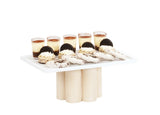 A white-washed pine wood rectangular platter on pedestal riser bases holds six small dessert cups topped with cocoa powder, four cream-filled sandwich cookies, and several white chocolate-dipped cookies, all neatly arranged against a white background.
