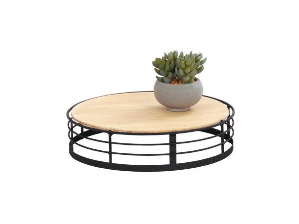 The Madison round coffee table features a light wood top and black metal frame base. A small gray pot with a green succulent rests on the table, showcasing its modern reversible design against a plain white background.