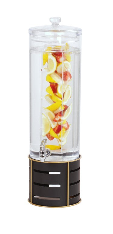 A tall Cal-Mil beverage dispenser with an infusion chamber is filled with water, sliced lemons, and red apple pieces. It has a spigot near the base and sits on a black and gold stand, isolated on a white background.