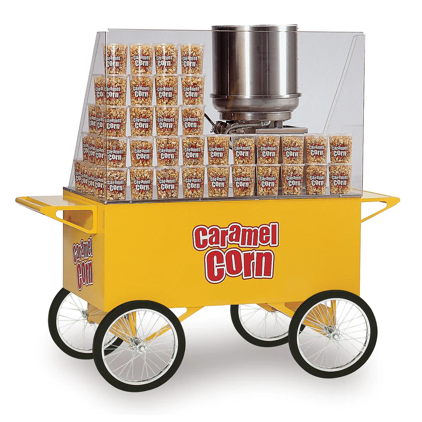 A yellow Caramel Corn Merchandiser cart with four large white wheels, a metal popcorn kettle, a clear shield, and stacks of caramel corn boxes inside. "Caramel Corn" is printed in red and white on this Gold Medal Products cart.