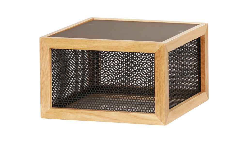 A square wooden-framed Camden riser features black perforated metal mesh sides and a solid black top and bottom. Displayed on a white background, its modern, minimalist aesthetic shines with a geometric, reversible design.