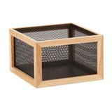 A square storage box with a light wooden frame and black metal mesh sides and bottom, featuring a fine, grid-like mesh. The Camden box has a reversible design for versatile use and is empty, shown on a white background.