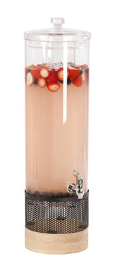 A tall, clear 3 gallon beverage dispenser filled with light pink liquid, ice, and floating berries including strawberries and blueberries. The dispenser has a silver spigot, perforated dark metal base with an ice chamber, and a wooden bottom.