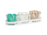 Three glass jars in a white metal tray create a tidy condiment jar display, holding teal, white, and brown sugar or sweetener packets neatly upright and grouped by color. The clear jars keep everything organized and easy to see.