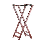 A wooden folding luggage rack with an X-frame design, rich mahogany finish, and two black straps across the top to support suitcases. The rack, resembling a tray stand, stands open on a white background.