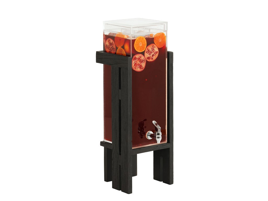 A clear Brooklyn Ice Beverage Dispenser with a polycarbonate chamber holds dark red liquid, garnished with orange and pomegranate slices. The dispenser features a silver spigot and stands elevated on a tall black wooden stand against a white background.