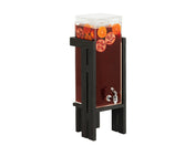 A clear Brooklyn Ice Beverage Dispenser with a polycarbonate chamber holds dark red liquid, garnished with orange and pomegranate slices. The dispenser features a silver spigot and stands elevated on a tall black wooden stand against a white background.