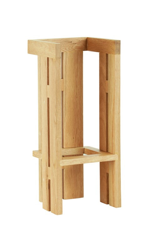 A minimalist oak wooden stool with a geometric design, featuring clean lines, a rectangular seat, and four legs connected by horizontal and vertical supports. The natural wood grain adds modern style and sturdy appeal.