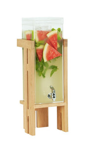 A tall, clear 3 gallon Sydney Beverage Dispenser on a sturdy oak stand, filled with light yellow lemonade, large watermelon slices, and mint leaves. The dispenser features a silver spigot near the bottom for easy pouring.