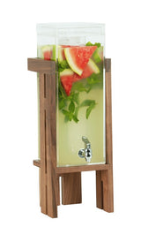 A tall, clear Sydney Beverage Display with a removable spigot and walnut wooden stand, filled with yellow-green lemonade, fresh mint, ice, and large watermelon slices, stands against a crisp white background.