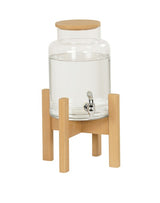 A clear glass water dispenser with a wooden lid sits on a light wood stand. Perfect for beverage display, it features a silver spigot for easy pouring. The simple, modern design uses natural materials for a stylish touch.
