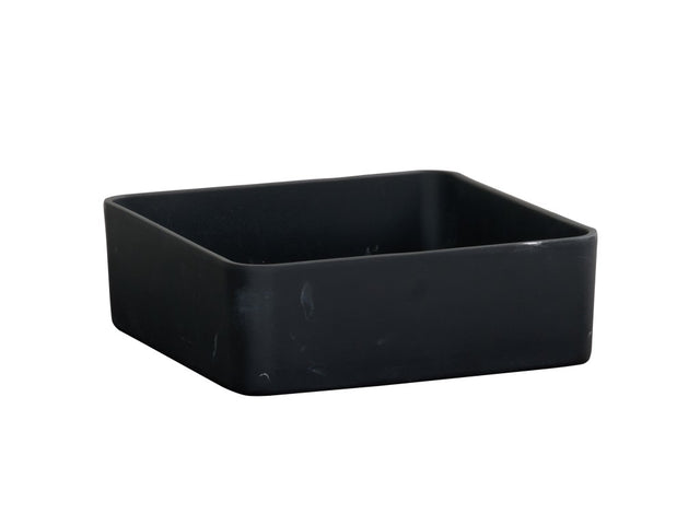 A matte black resin bowl, square-shaped with rounded edges, sits on a white background. The surface shows subtle scuff marks, and the container appears empty.
