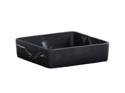 A square, deep black ceramic bowl with slightly curved sides and a subtle black swirl pattern on its exterior. The dish has a matte finish and a minimalist design, set against a plain white background.
