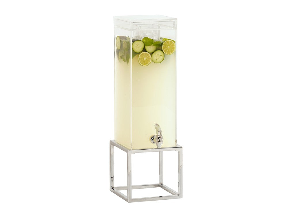 A tall, clear polycarbonate chamber ice beverage dispenser filled with pale yellow drink, topped with lime, cucumber slices, and mint leaves. The dispenser has a chrome plate finish spigot and sits on a modern, open silver metal stand.
