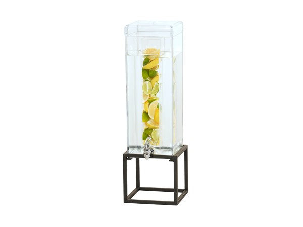 A tall, clear Infusion Beverage Dispenser with a 3 gal. polycarbonate chamber sits on a black metal stand. Filled with water and stacked slices of lemons and limes, it features a silver spigot at the bottom for easy pouring.