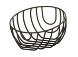 A black wire fruit bowl, like the Cal-Mil Madison Wire Basket, features an open, geometric design. This oval-shaped basket is made of curved metal rods for a modern, minimalist look against a plain white background.
