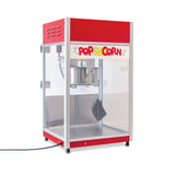 A red and silver popcorn machine with an 8 oz kettle and glass sides sits on a white countertop. “Popcorn” is written in colorful letters on the front panel, decorated with popcorn illustrations. The serving tray and power cord are visible inside.