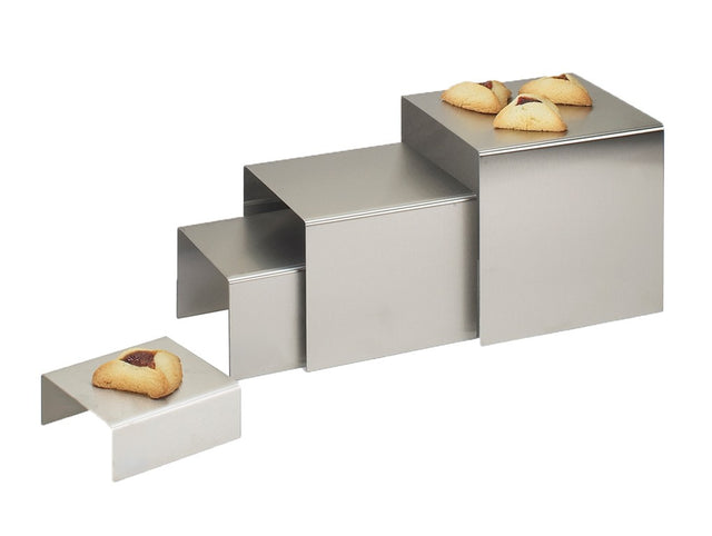 Four Classic Riser metal display stands by Cal-Mil, crafted from stainless steel and increasing in height, are arranged in a row. Atop each riser sits a hamantaschen cookie with visible fruit filling, set against a plain white background.