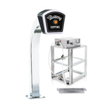 A shiny metal Popcorn Topping Dispenser labeled Buttery Topping features a curved stand and an LED lighted sign on top. Next to it, a metal pump system with hoses connects to a small rectangular tray on the ground. The background is plain white.
