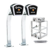 Two tall, shiny Popcorn Topping Dispensers labeled Buttery Topping stand next to a metal pump machine with tubing, a metal shelf stand, and a shallow metal tray, all beneath an LED lighted sign on a white background.