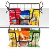 A black powder coated, two-tier metal basket snack rack holds colorful chip and snack bags. The top tier has Cheez-It, Teddy Grahams, and Keebler Elf Grahams; the bottom holds Cheetos Baked and Lay’s Baked. The rack sits on a white table.