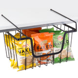 A black powder coated metal basket hangs from a white shelf, holding multiple bags of Lay’s and Cheetos Baked chips. The stackable hanging basket keeps snack storage organized with colorful bags showing BAKED and 65% less fat.