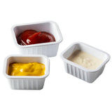 Three small, white melamine sauce cups hold different condiments—bright red ketchup, yellow mustard, and white mayonnaise—arranged closely on a plain white background as part of the Better Burger Collection.