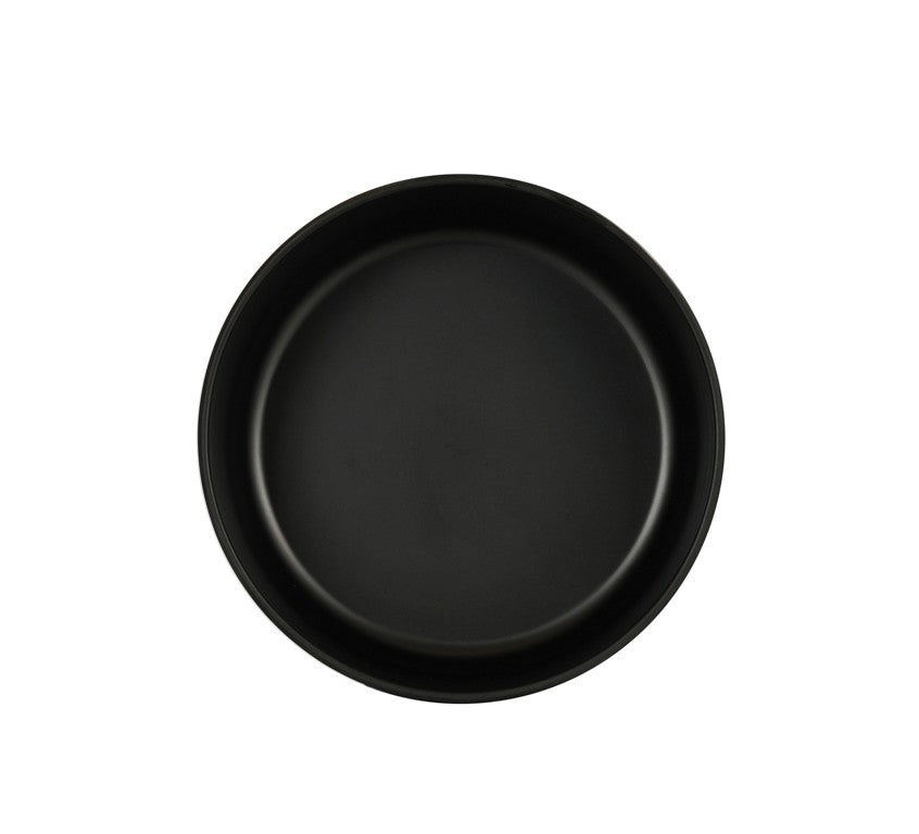 A simple, round, black Oslo Bowl viewed from above against a plain white background. The plate has a smooth, matte finish with slightly raised edges and is empty, creating a minimalist and modern appearance.