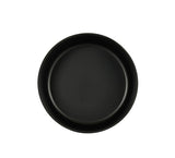 A simple, round, black Oslo Bowl viewed from above against a plain white background. The plate has a smooth, matte finish with slightly raised edges and is empty, creating a minimalist and modern appearance.