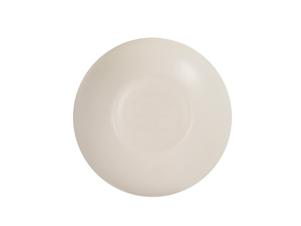 A round, beige silicone breast implant is shown against a white background. The surface is smooth with a matte finish, resembling an Oslo Bowl or melamine bowl, and faint embossed text in the center indicates product information. The implant appears unused and clean.