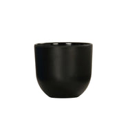 A matte black ceramic cup with a smooth, rounded shape and no handle, set against a plain white background. Reminiscent of the Oslo Bowl, it features a slightly curved base, straight rim, and minimalist modern design.