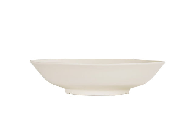 A plain, white, shallow Hand Thrown Bowl with a slightly irregular, organic-shaped rim. Photographed from the side against a white background, it highlights the bowl’s minimalistic and modern design. Dishwasher safe for easy cleaning.