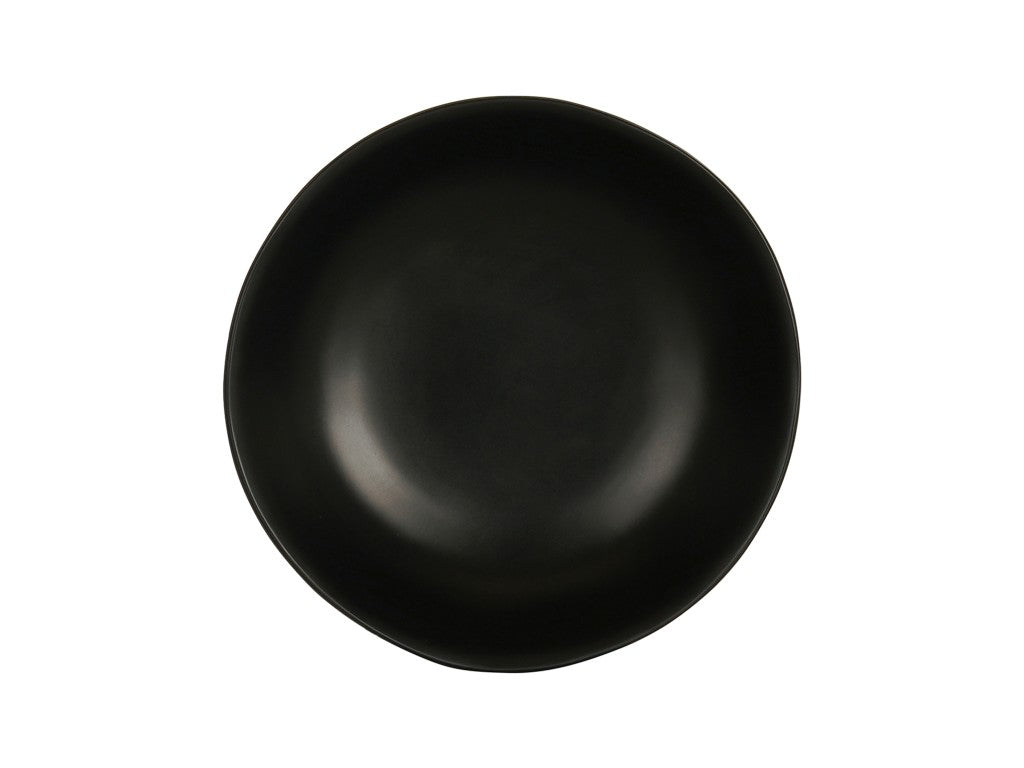 A round, matte black plate with slightly uneven edges is centered on a white background. With a smooth surface and minimalist, modern design, this dish is also dishwasher safe for easy cleaning.