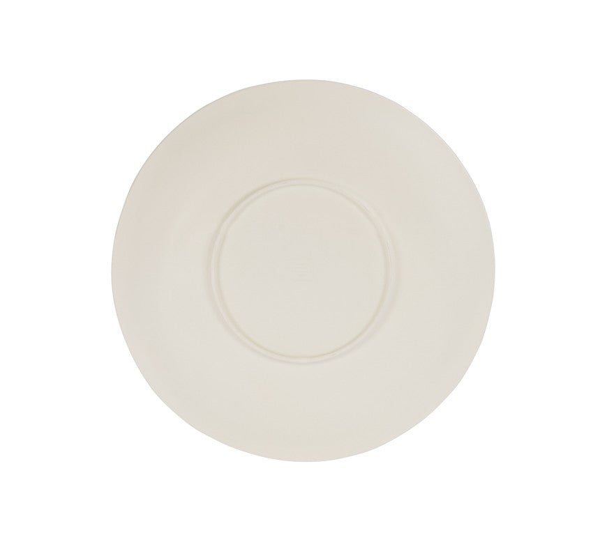 A plain, round, off-white ceramic plate viewed from above, featuring a slightly raised rim and a subtle indented circle near the center. Reminiscent of a hand thrown bowl, it sits against a completely white background.