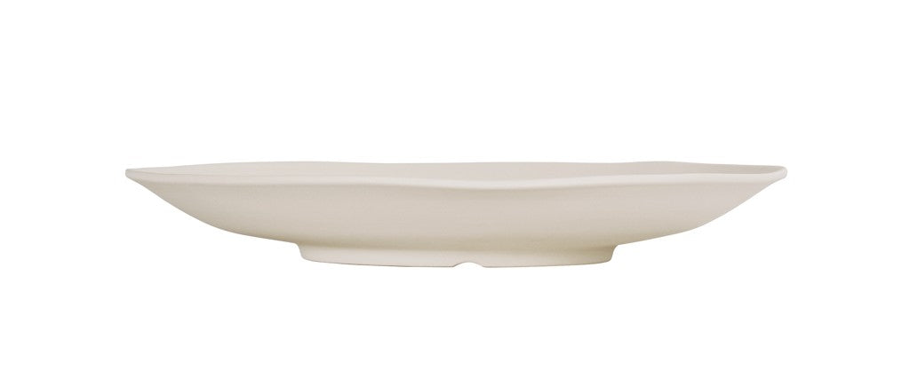 A white, shallow, oval-shaped ceramic plate with slightly wavy edges is shown in profile against a plain white background. Dishwasher safe, it features a smooth surface and sits on a small, rounded base for added elegance.