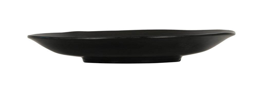 A matte black, round ceramic plate with a slightly irregular, wavy rim and flat central surface. Viewed from the side, this Hand Thrown Bowl features a shallow depth and slightly raised base. The background is plain white.