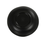 A matte black plate, reminiscent of a Hand Thrown Bowl, is shown upside down against a white background. The plate has an organic shape with a raised circular base in the center, embossed text, and a small logo. Dishwasher safe for easy cleaning.